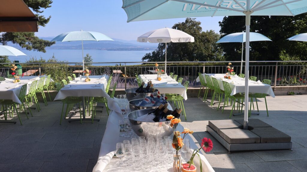 Terrasse panoramique avec parasols et vue sur le lac au Signal de Bougy